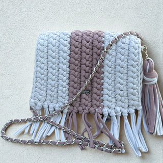 Woven handbag with tassels and a chain strap on a light background