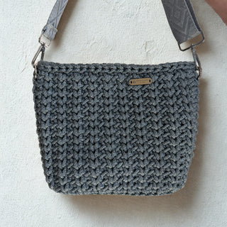Gray textured handbag with a strap on a light background