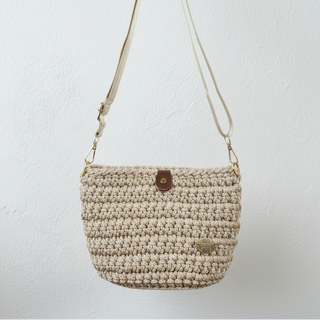 Beige crochet handbag with a strap on a light gray background