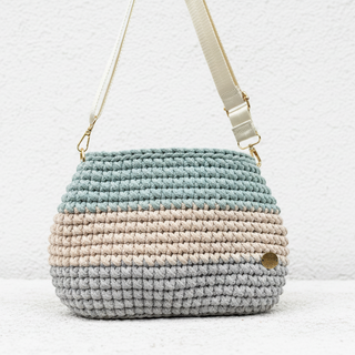 Crocheted bag with a gradient color pattern on a white background