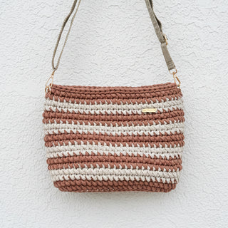 Crocheted handbag with brown and white stripes on a light gray background