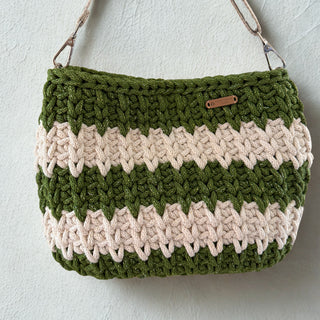 Green and beige striped crochet bag on a light gray background