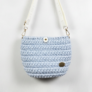 Light blue woven handbag with a strap on a gray background