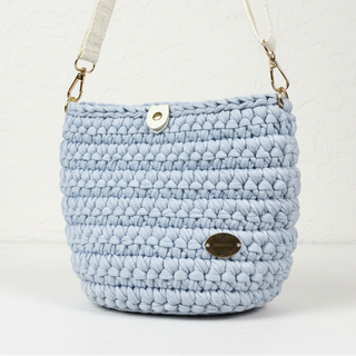 Light blue crocheted bag with a strap on a white background