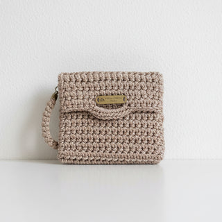 Crocheted beige bag with a visible brand label on a white background