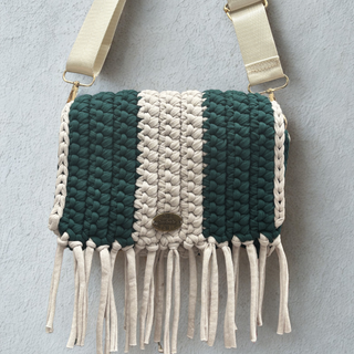 Handmade crochet crossbody bag in ultramarine green and stone with tassel detail and a shoulder strap.