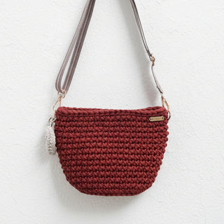 Red crochet handbag with a strap on a white background