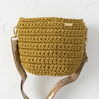 Crocheted mustard yellow handbag with a gold strap on a white background