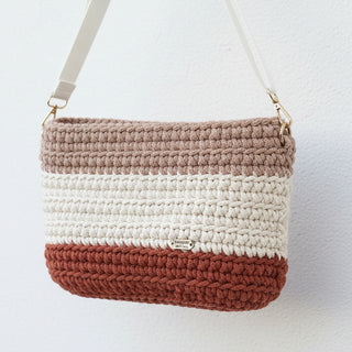 Crocheted handbag with three color stripes on a white background