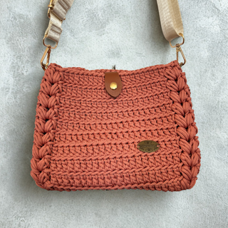 Crocheted handbag with a strap on a gray background