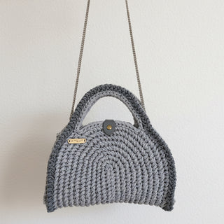 Gray knitted handbag with a strap on a light background