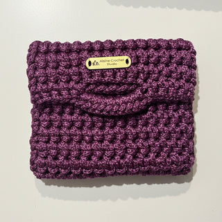 Purple knitted product with a brand label on a light gray surface