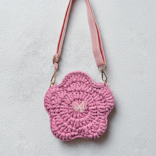 Pink crochet bag with a butterfly design on a light background
