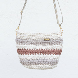 Crocheted handbag with striped pattern on a textured surface