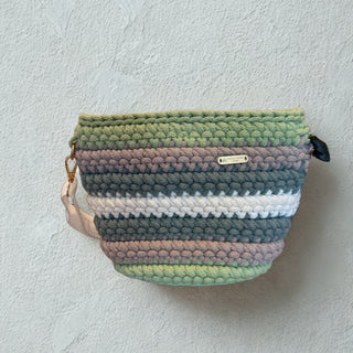 Multicolored striped pouch with a brand label on a light gray background