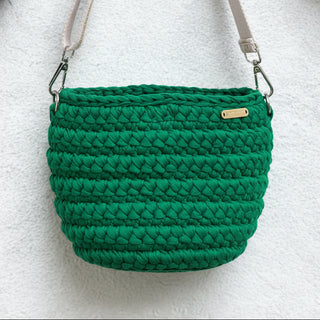 Green woven handbag on a gray surface