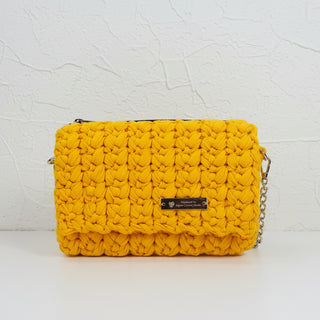 A handmade crochet clutch bag in yellow.